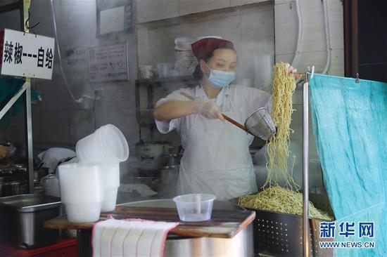 4月22日，武汉市粮道街的家阳“赵师傅”天天红油热干面店厨师在制作热干面。新华社记者 沈伯韩 摄